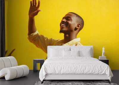 A smiling man holding his hand up in a gesture of confidence, vibrant yellow background, casual outfit with rolled-up sleeves, dynamic Wall mural